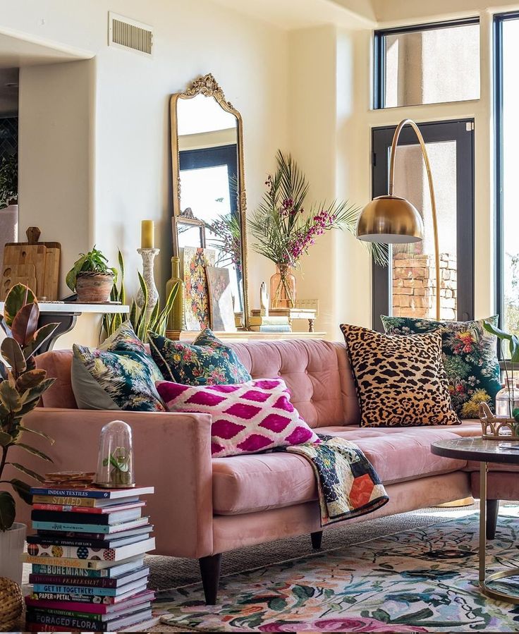 Soft, sunlit living room with a blush velvet sofa, patterned pillows, and layered florals — reflecting the Alluring Romantic’s refined yet inviting aesthetic.